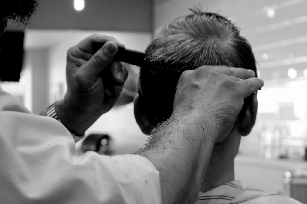 Barbeiro cortando o cabelo de um cliente (foto ilustrativa, banco de imagens gratuito)